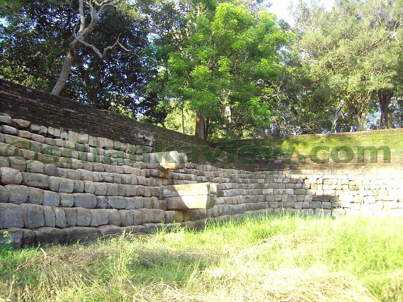 A corner of the pond and the stone blocks bordering the pond walls. 