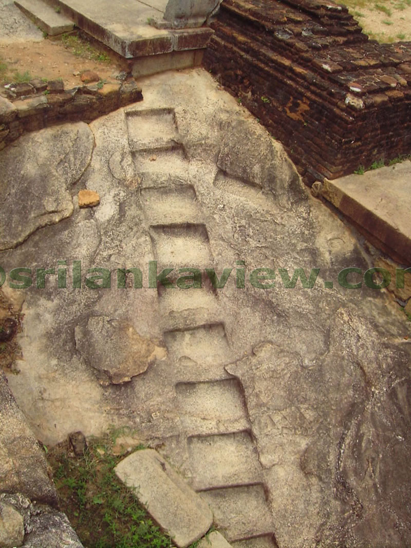 Stone steps carved along rock to approach upper level of the building.