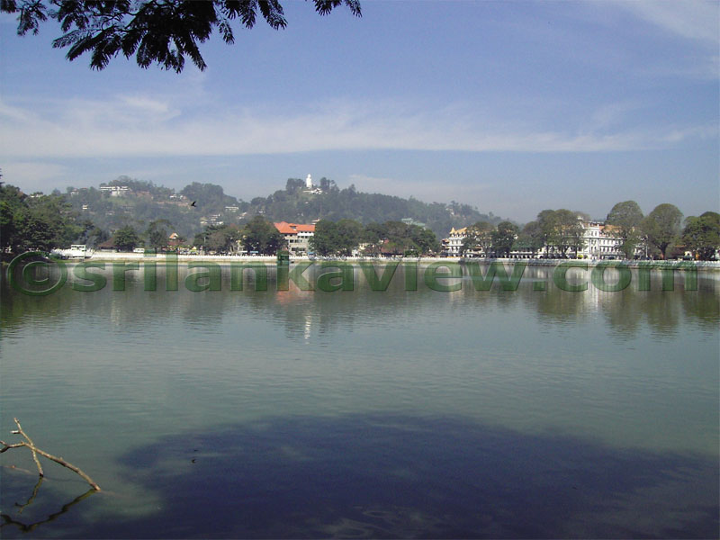 View of Kandy lake and the Sculptured Seated Buddha Figure at a distant hill top.