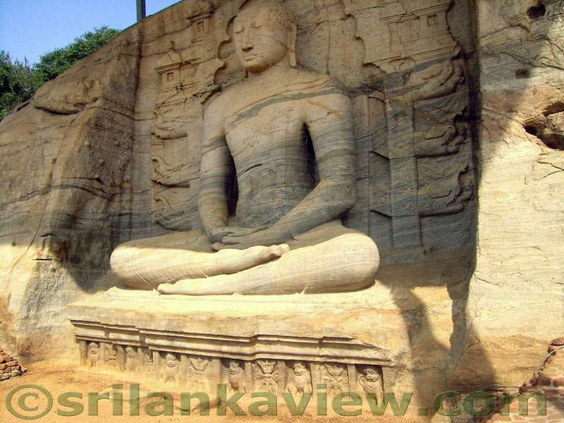 The Seated Buddha Statue of Gal Viharaya, Polonnaruwa.The fine sculpturing of the Buddha Image is clearly seen here.Notice the background images and the lion figures at the bottom of the stone throne.