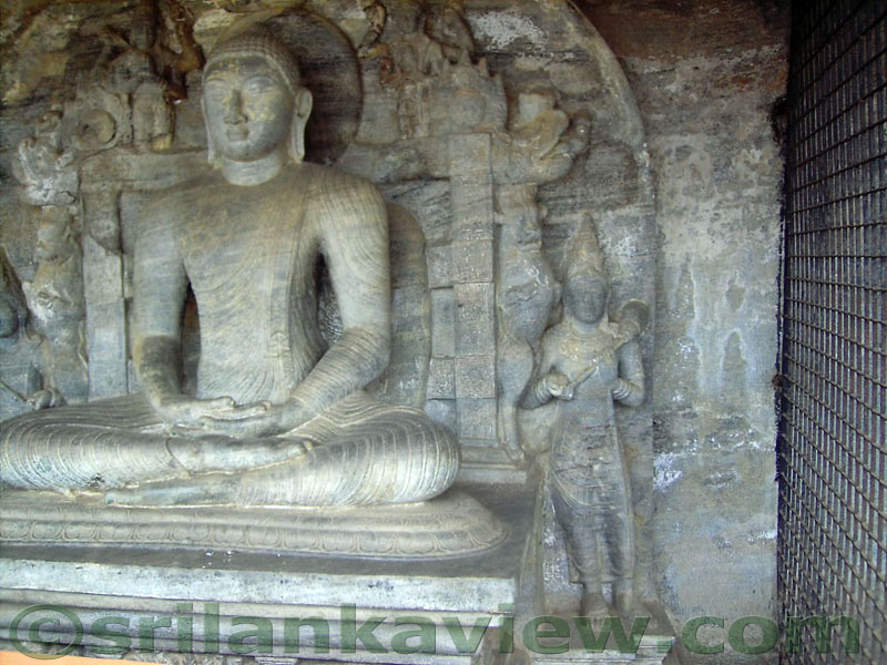 The Samadhi Buddha statue in the 'Nisinna Patima Guha' on a throne and the God Brahma is sculptured in the upper left side of the Buddha statue.