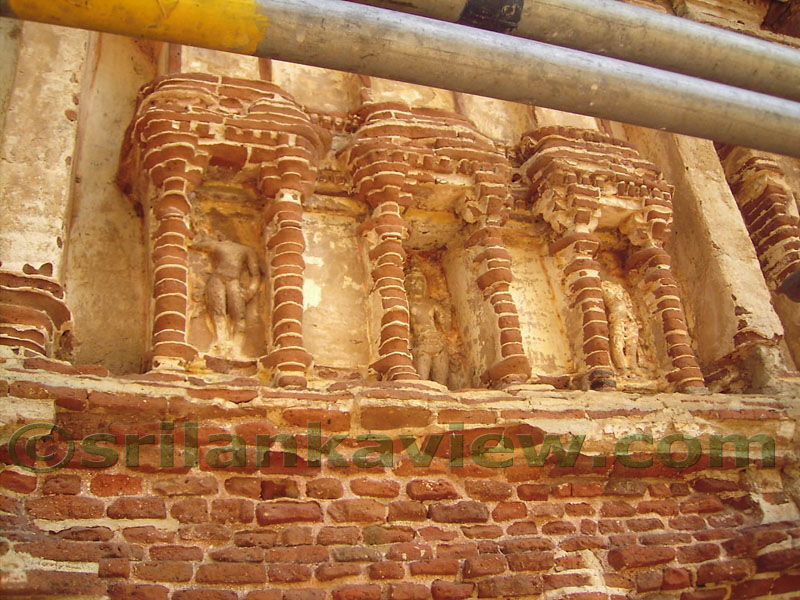 Sculptured figures inside niches of outer brick walls.