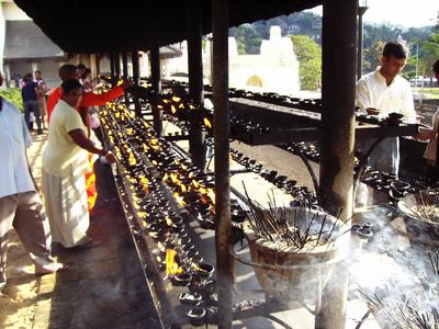 Lighting of lamps as homage to the Buddha by using coconut oil -Temple of the Tooth Relic