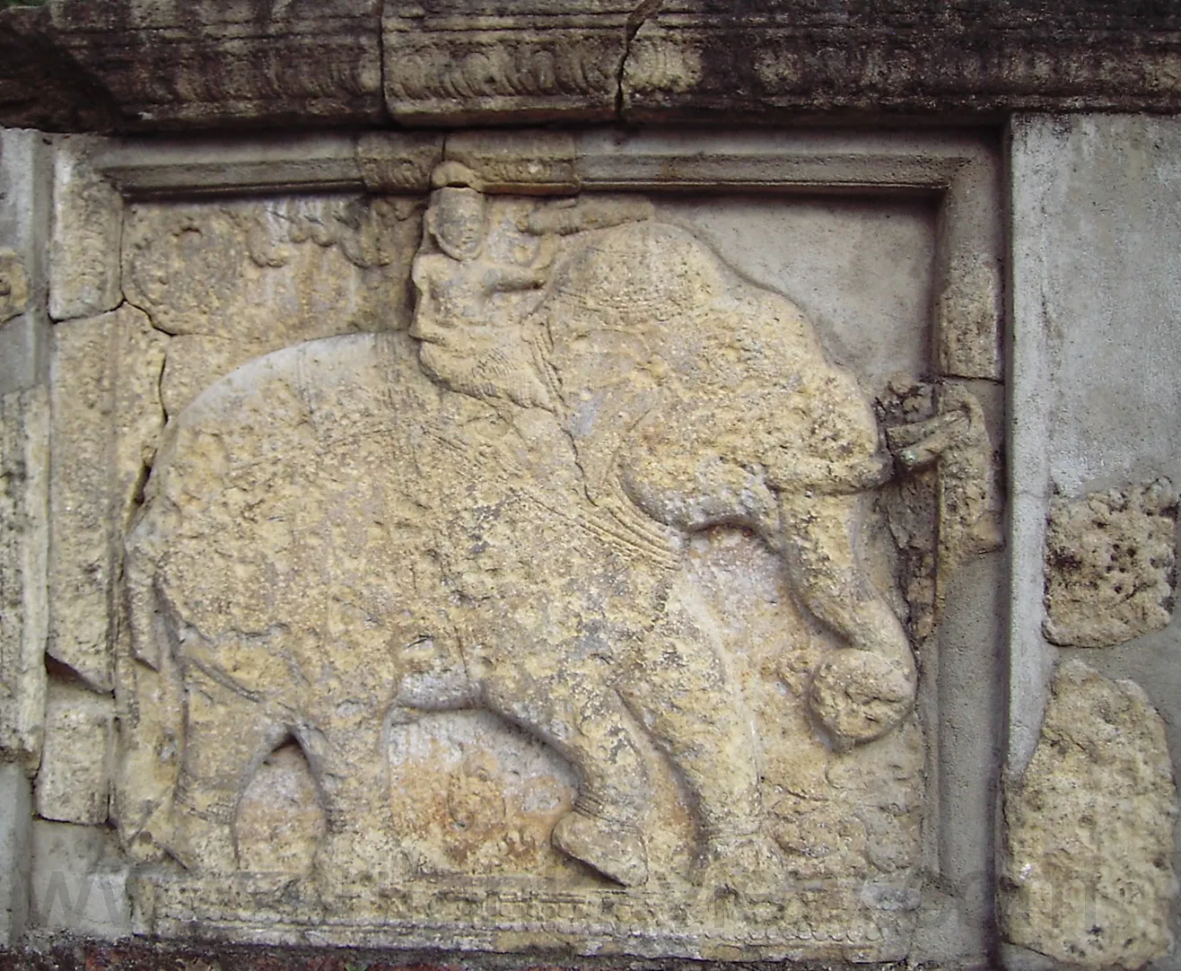 Photograph image of the partially destroyed( during terrorist attack) Stone sculptured slab with elephant and man on his back -Temple of Tooth, Dalada Maligawa