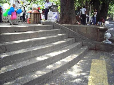Stone retaining wall and the stone steps of entrance to Kandy Lake walkway.Below the decorative wall is the main road which is below the water level.